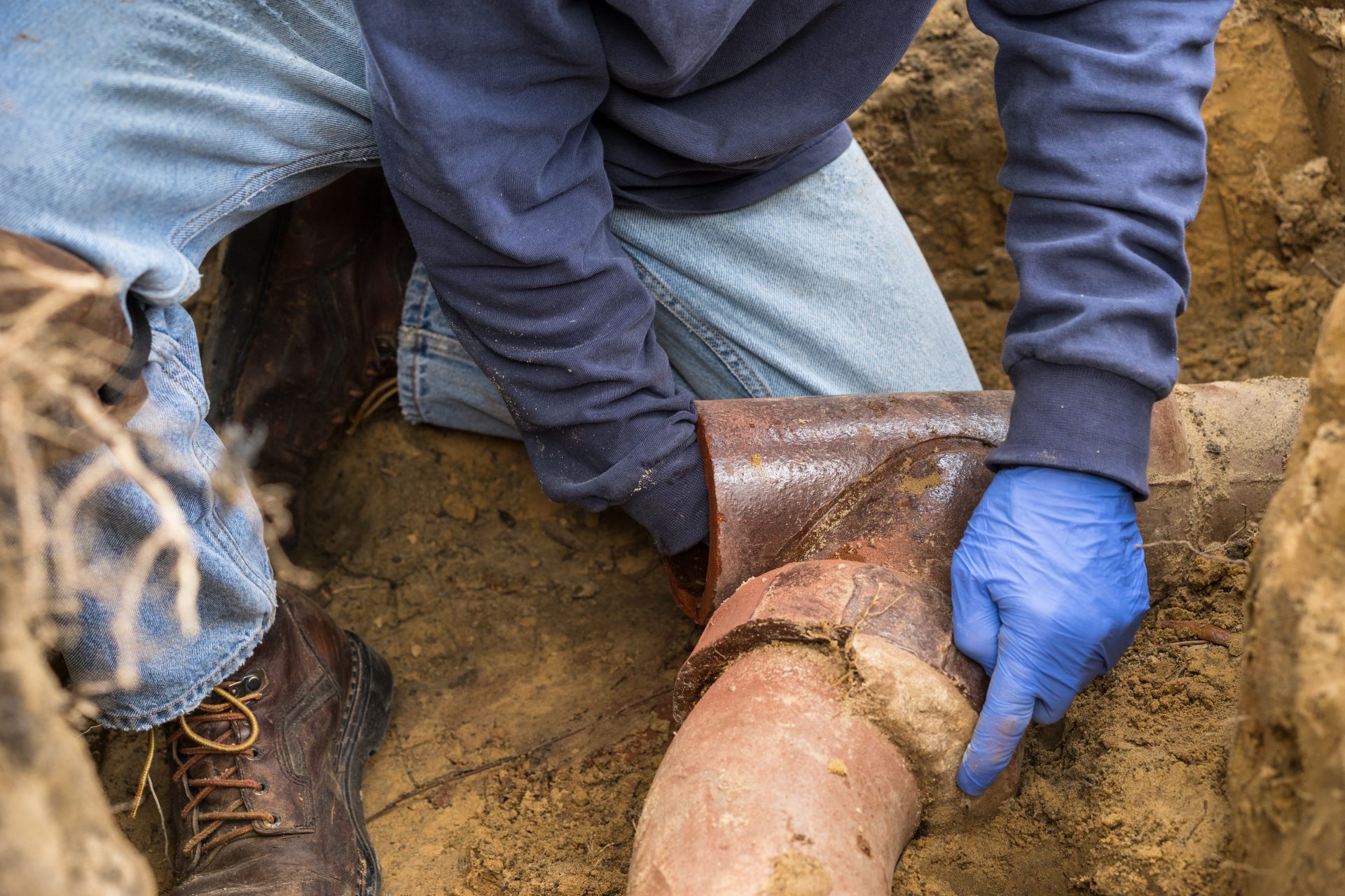 Man Digging Out Clogged Sewer Line Closeup